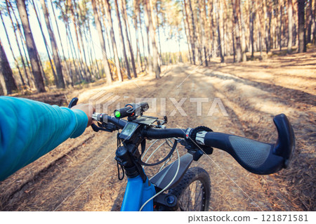 man cyclist rides in the forest on a mountain bike. first person view man cyclist rides in the forest on a mountain bike. first person view 121871581