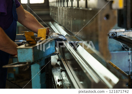 Precision metalwork at a manufacturing facility during daylight hours 121871742