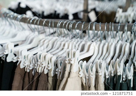 Clothing racks display a variety of stylish pants in a retail store setting 121871751