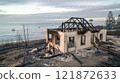 Post-Wildfire Scene of Burned Beachfront Properties and Scorched Landscape 121872633
