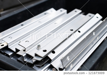 Many precisely bent profile products from stainless steel sheets in a factory or warehouse. Raw materials or semi-finished products for stainless steel structures Many precisely bent profile products from stainless steel sheets in a factory or warehouse. Raw materials or semi-finished products for stainless steel structures 121873009