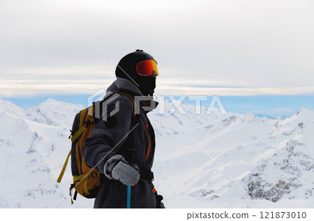 ski resort vacation. guy standing and enjoying views in snowy mountains. sportsman skiing in alps ski resort vacation. guy standing and enjoying views in snowy mountains. sportsman skiing in alps 121873010