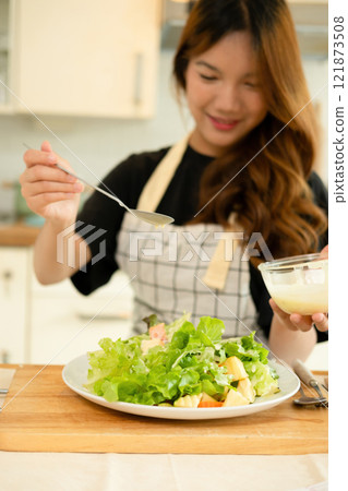 A woman enjoy making salad in the kitchen A woman enjoy making salad in the kitchen 121873508