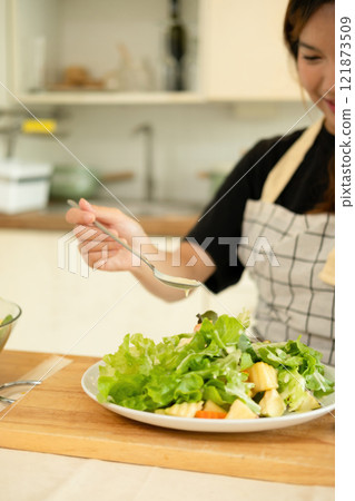 A woman enjoy making salad in the kitchen A woman enjoy making salad in the kitchen 121873509