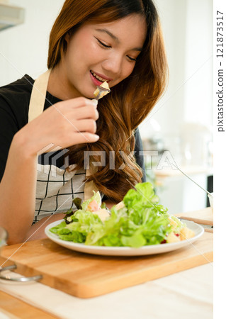 A female homecook enjoying her salad 121873517