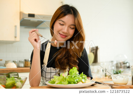 A female homecook enjoying her salad A female homecook enjoying her salad 121873522