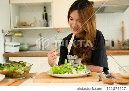 A female homecook enjoying her salad A female homecook enjoying her salad 121873527