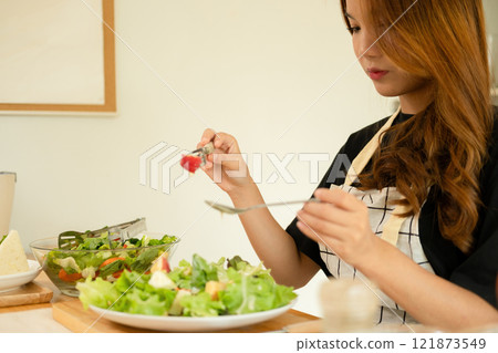 A female homecook enjoying her salad A female homecook enjoying her salad 121873549
