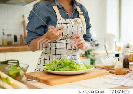 A home-cook eating her own salad A home-cook eating her own salad 121873603