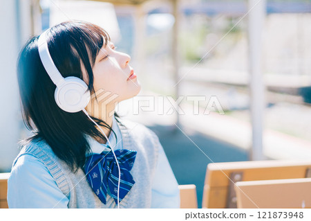 高中女生在車站的平台上聽音樂 121873948