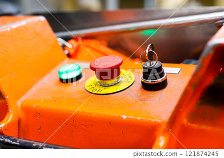 Control panel with multi-colored buttons for controlling production equipment and production line. Large red button and key for activation Control panel with multi-colored buttons for controlling production equipment and production line. Large red button and key for activation 121874245