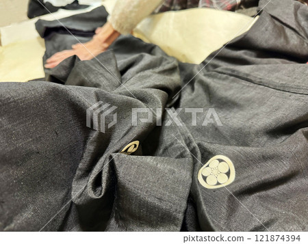 An elderly woman folding a men's crested garment on wrapping paper An elderly woman folding a men's crested garment on wrapping paper 121874394