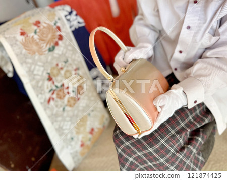 一個戴著白手套、拿著和服袋的女人 一個戴著白手套、拿著和服袋的女人 121874425