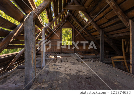 Perspective view of a dark abandoned attic room with holes in roof 121874623