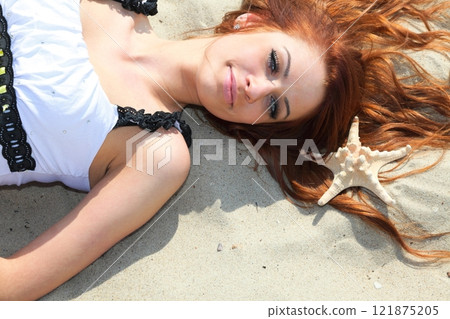 The beautiful girl lies on sea coast with shells nature vacation 121875205