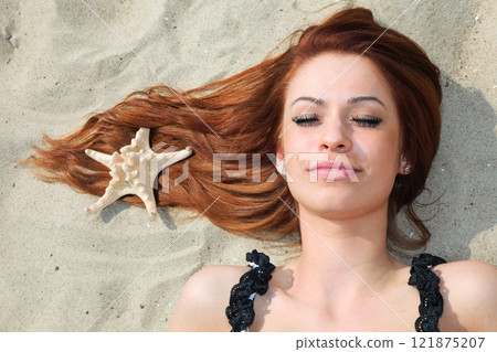 The beautiful girl lies on sea coast with shells nature vacation 121875207