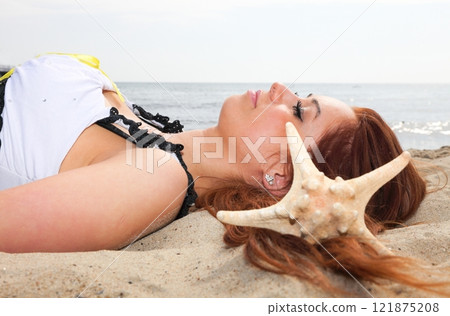The beautiful girl lies on sea coast with shells nature vacation The beautiful girl lies on sea coast with shells nature vacation 121875208