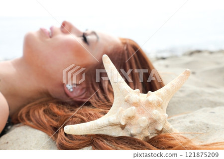 The beautiful girl lies on sea coast with shells nature vacation The beautiful girl lies on sea coast with shells nature vacation 121875209