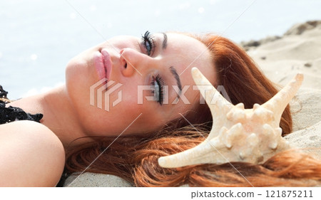 The beautiful girl lies on sea coast with shells nature vacation 121875211