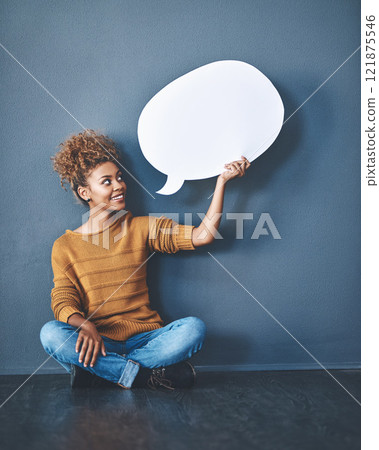 Smiling woman holding a blank white speech bubble and copyspace. Lady looking at an empty cut out to announce a sale or marketing concept. Female voice opinion on a social media chat display 121875546