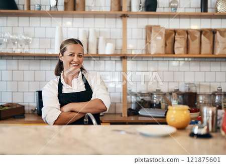 Business owner, barista standing with arms crossed, looking confident and proud while working at a restaurant. Cafe worker, employee and entrepreneur smiling, giving service and leading a coffee shop 121875601