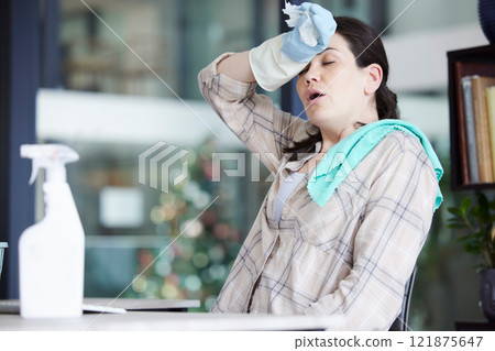 Tired, stressed and frustrated cleaning lady resting after doing chores, hygiene and housework alone indoors. Exhausted and overworked domestic housewife wiping sweat with gloves on a break at home 121875647