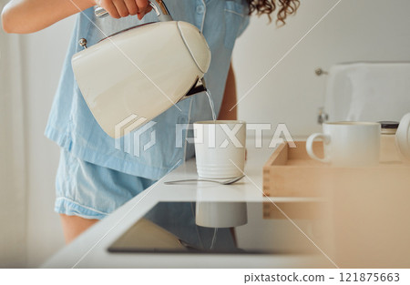Morning, breakfast coffee and female hands pouring water in cup from retro kettle in kitchen at home. Woman in pajamas brewing tea or making a beverage on counter to start the day. Morning, breakfast coffee and female hands pouring water in cup from retro kettle in kitchen at home. Woman in pajamas brewing tea or making a beverage on counter to start the day. 121875663