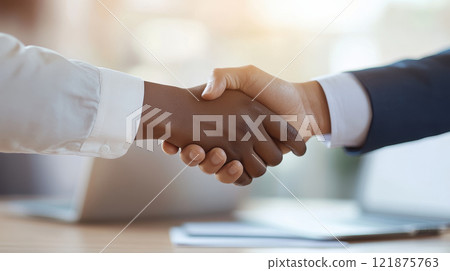 close up of two business professionals shaking hands, symbolizing partnership and agreement in modern office setting 121875763