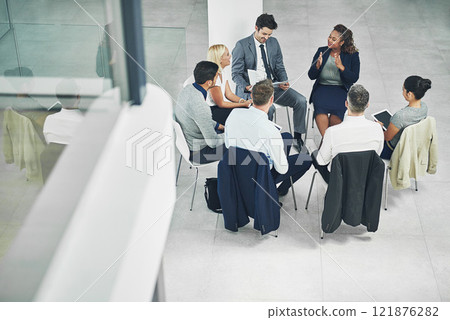 Teamwork, working together and strategy with a female leader and group or team of business people and colleagues talking in a meeting. Discussing plans and ideas in a workshop or seminar from above 121876282