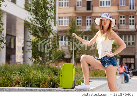 Attractive woman tourist with suitcase ready to travel 121876402
