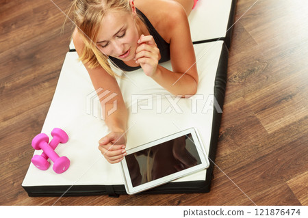 Fit woman lying on floor with tablet pc Fit woman lying on floor with tablet pc 121876474