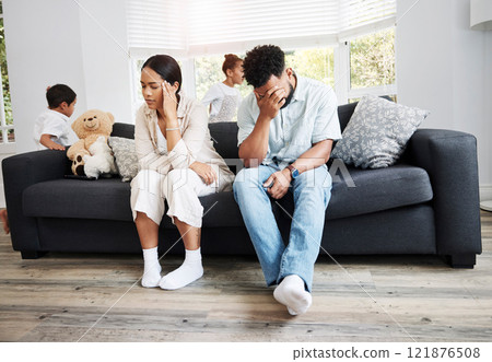 Sad, unhappy and stressed parents sitting on a couch near their children at home after an argument. Frustrated, tired and annoyed mom and dad are angry at hyperactive, noisy and naughty kids 121876508