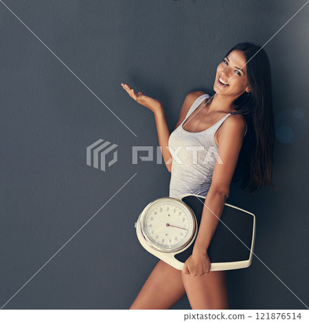 Copy space for a health gym, weight loss and fitness advert by young woman showing her hands and holding a scale. Female smiling while presenting the benefits of a balanced diet and healthy lifestyle 121876514