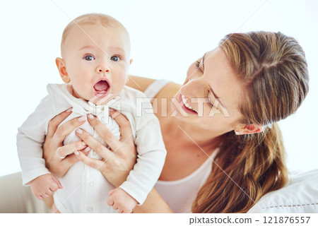 Happy, young and single mother bonding and taking care of adorable baby, enjoying parenthood and being a new mom. Happy female experiencing maternal instinct, holding cute, little child on a bed. 121876557