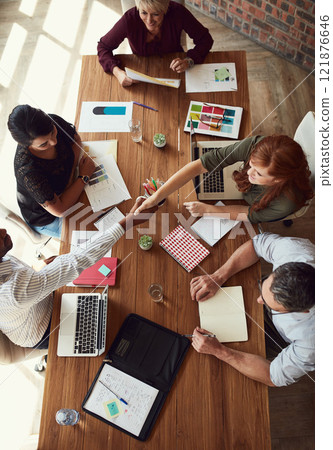 Handshake, agreement and greeting team of creative designers during a meeting working together. Overhead view of a diverse group of artists or creators planning for a design business or company 121876646