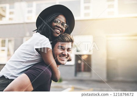 Young playful interracial couple playing, bonding and hugging while standing in the city together on weekend. Happy husband giving wife a piggyback ride, enjoying a day in the urban town or traveling Young playful interracial couple playing, bonding and hugging while standing in the city together on weekend. Happy husband giving wife a piggyback ride, enjoying a day in the urban town or traveling 121876672