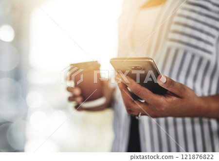 Closeup of a casual business woman using a phone for communicating with clients while working remotely from home with flare. Professional black female employee holding her work and personal cellphone 121876822