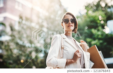 Elegant woman holding shopping bags after a spending spree, retail therapy and buying clothes in a city. Trendy, stylish and fashionable lady purchasing gifts, presents and classy clothing downtown Elegant woman holding shopping bags after a spending spree, retail therapy and buying clothes in a city. Trendy, stylish and fashionable lady purchasing gifts, presents and classy clothing downtown 121876843