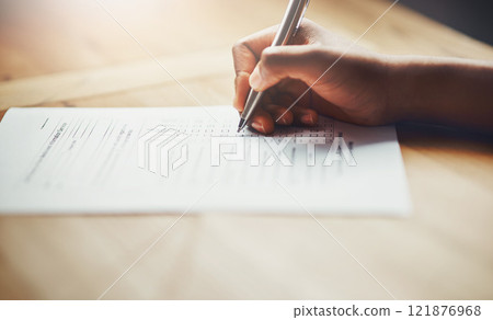 Closeup of business hands of a person filling out paperwork. Hand of an individual writing test, information or survey on paper to complete application or contract form on the desk at work. Closeup of business hands of a person filling out paperwork. Hand of an individual writing test, information or survey on paper to complete application or contract form on the desk at work. 121876968