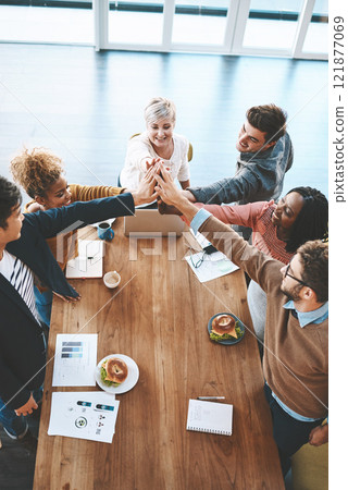 Diverse group of businesspeople high five after planning a meeting in an office. Above ambitious happy confident professional team of colleagues celebrating a success, achievement and feeling excited 121877069
