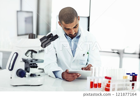 Scientist writing DNA results from microscope test on a tablet.Professional male doctor in a lab working with research tubes.Man in a modern laboratory doing medical science data analysis. 121877164