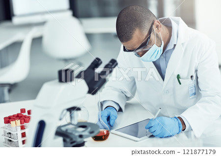 Scientist, researcher and medical worker using a tablet for innovation and research while wearing a face mask in a lab. Male chemist working to find a cure for covid virus in a science facility Scientist, researcher and medical worker using a tablet for innovation and research while wearing a face mask in a lab. Male chemist working to find a cure for covid virus in a science facility 121877179