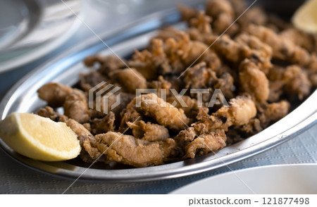 A plate with fried small delicious cuttlefish, grilled seafood closeup. 121877498