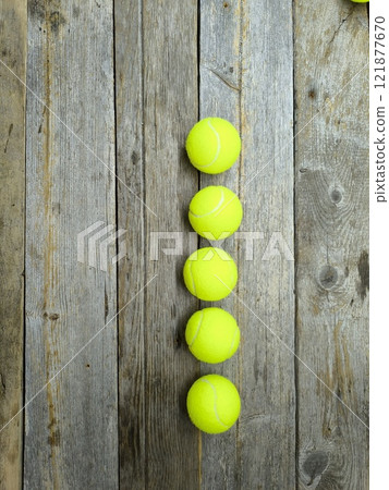 Creative sports scene with tennis balls on wooden table 121877670
