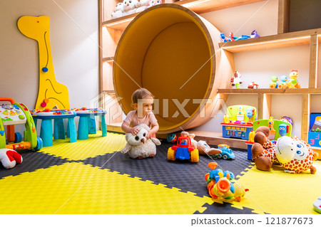 Child exploring toys and learning activities in a playful and colorful daycare setting Child exploring toys and learning activities in a playful and colorful daycare setting 121877673