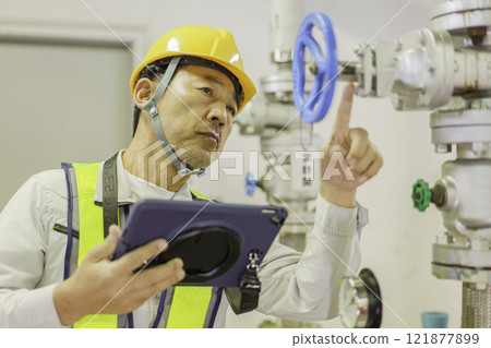 A male worker inspecting a valve. Photo courtesy of Denpa Gakuen, Tokyo Electronics College. 121877899