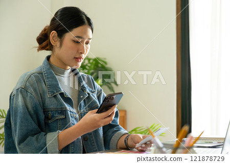 Young female architect uses smartphone to work. 121878729