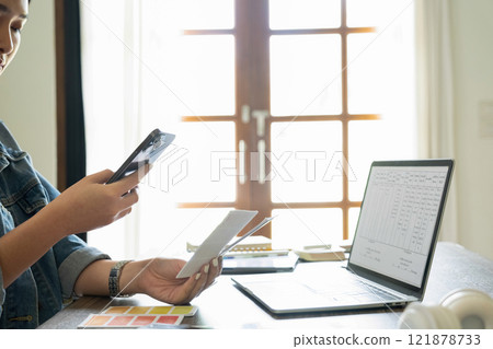 Young female architect uses smartphone to work. Young female architect uses smartphone to work. 121878733