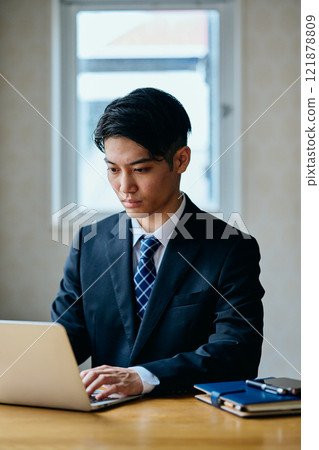 A young man in his twenties operating a personal computer A young man in his twenties operating a personal computer 121878809