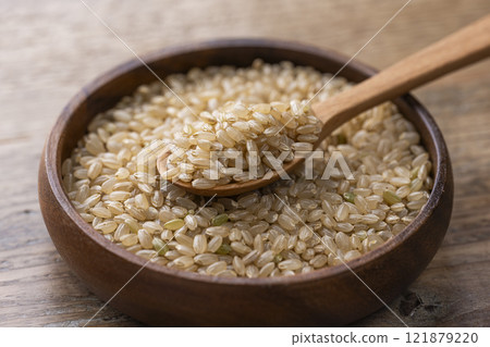 木桌上盤子上的糙米和木勺 121879220